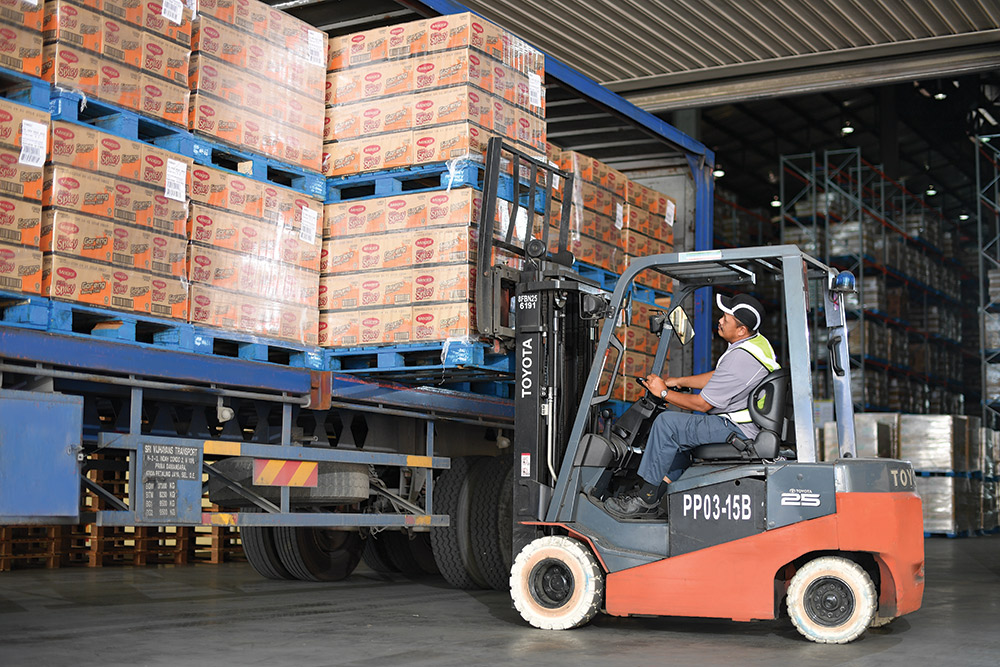 A forklift driver lifting crates of MAGGI products A forklift driver lifting crates of MAGGI products