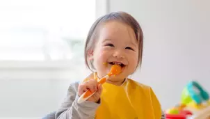 baby smiling while eating food