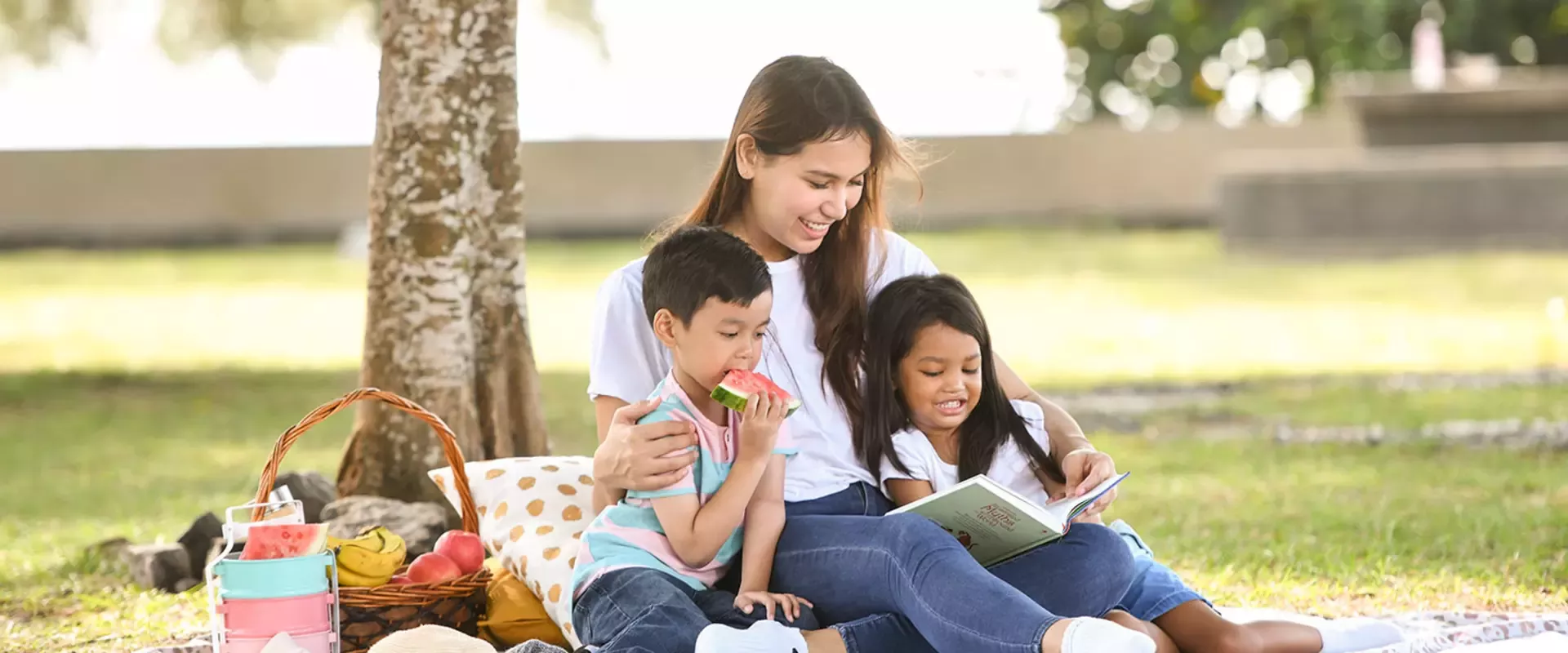 A young mother and two kids having a picnic.